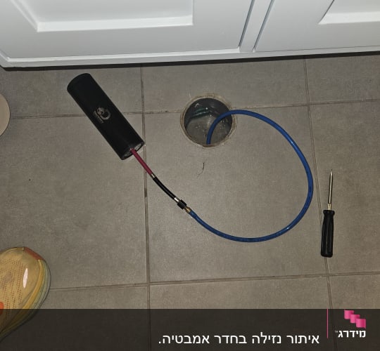 צינור כחול וכלי עבודה על רצפה אפורה